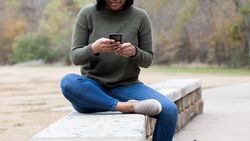 Looking at the phone on a ledge cropped compressed